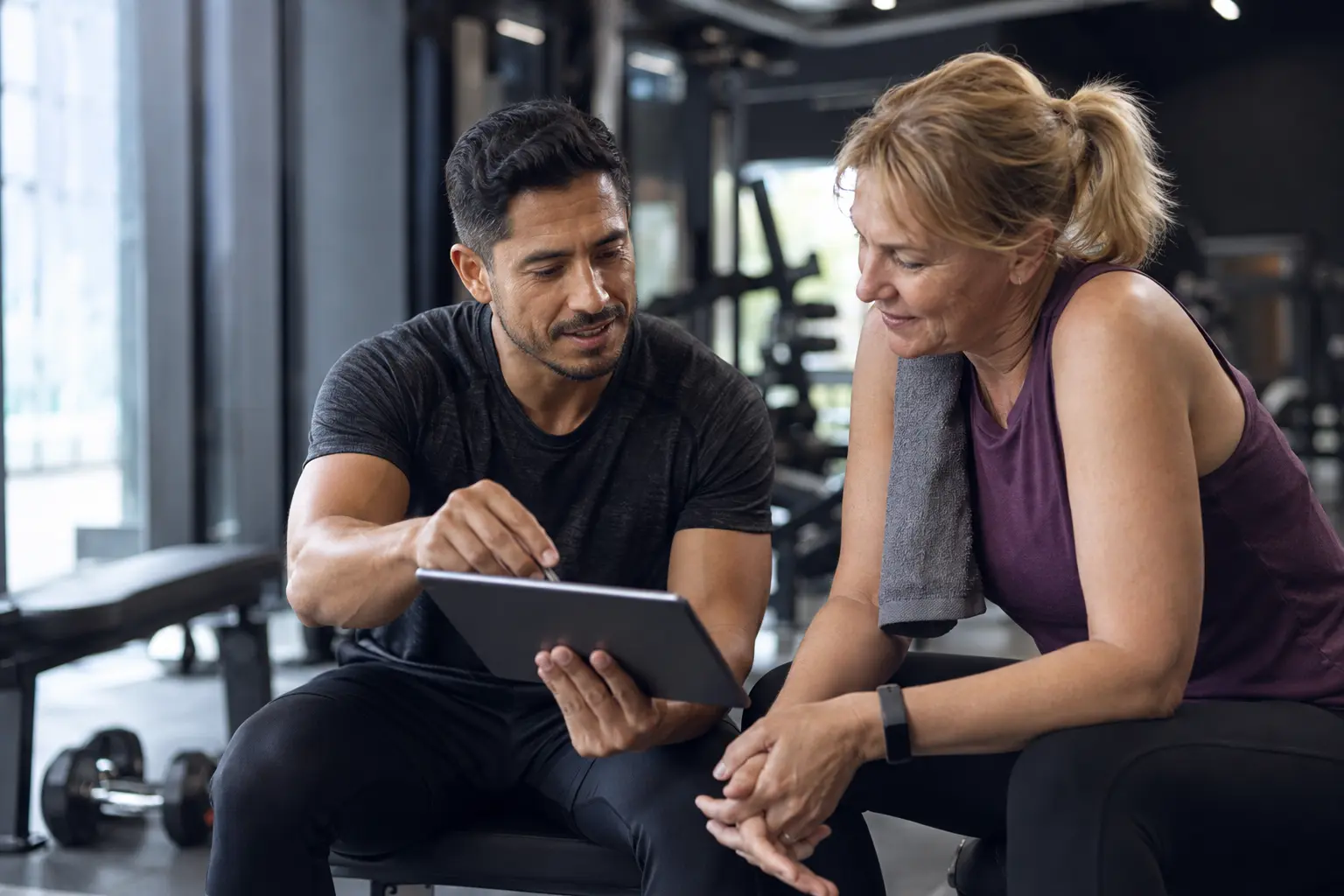 A fitness coach and client reviewing information together after a session